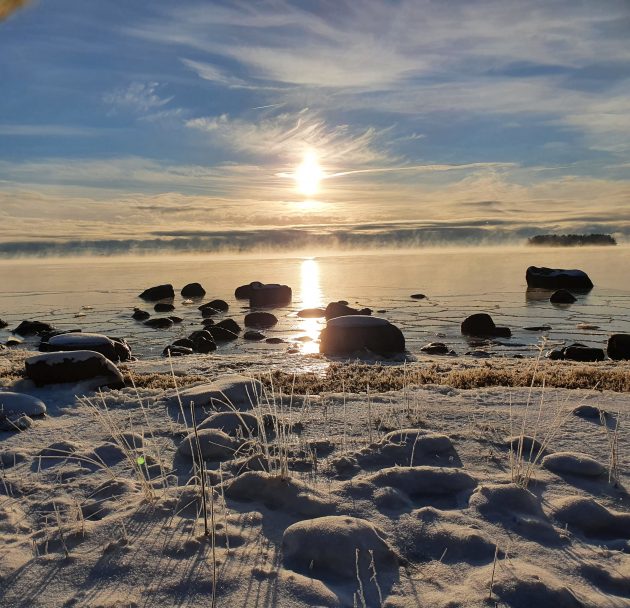 talvinen maisema, jossa rantakivia ja aurinko
