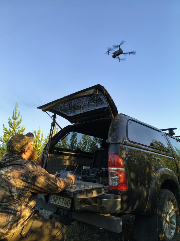 Metsästäjä ohjaamassa dronetta ilmaan.