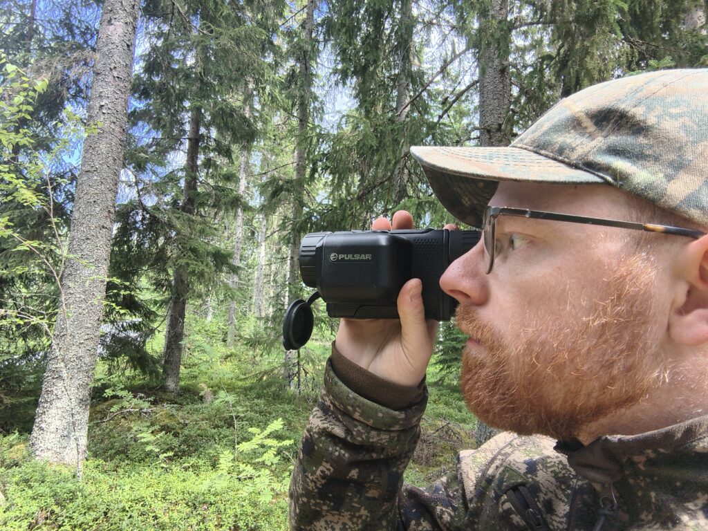 Metsästäjä tähystämässä lämpökameralla.