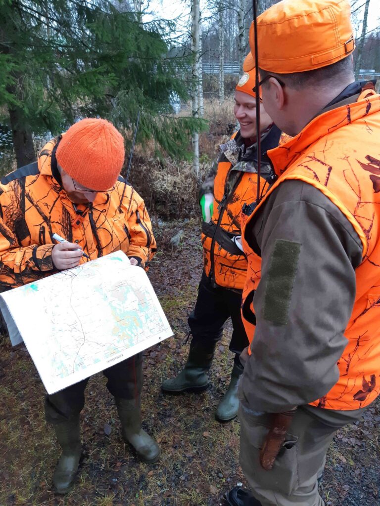 Metsästyksenjohtaja piirtää kartalle tulevaa ajoa.